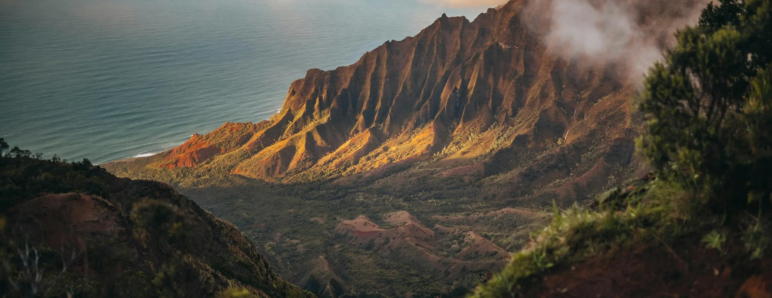 Sunlit ridgeline with steep cliffs overlooking the ocean