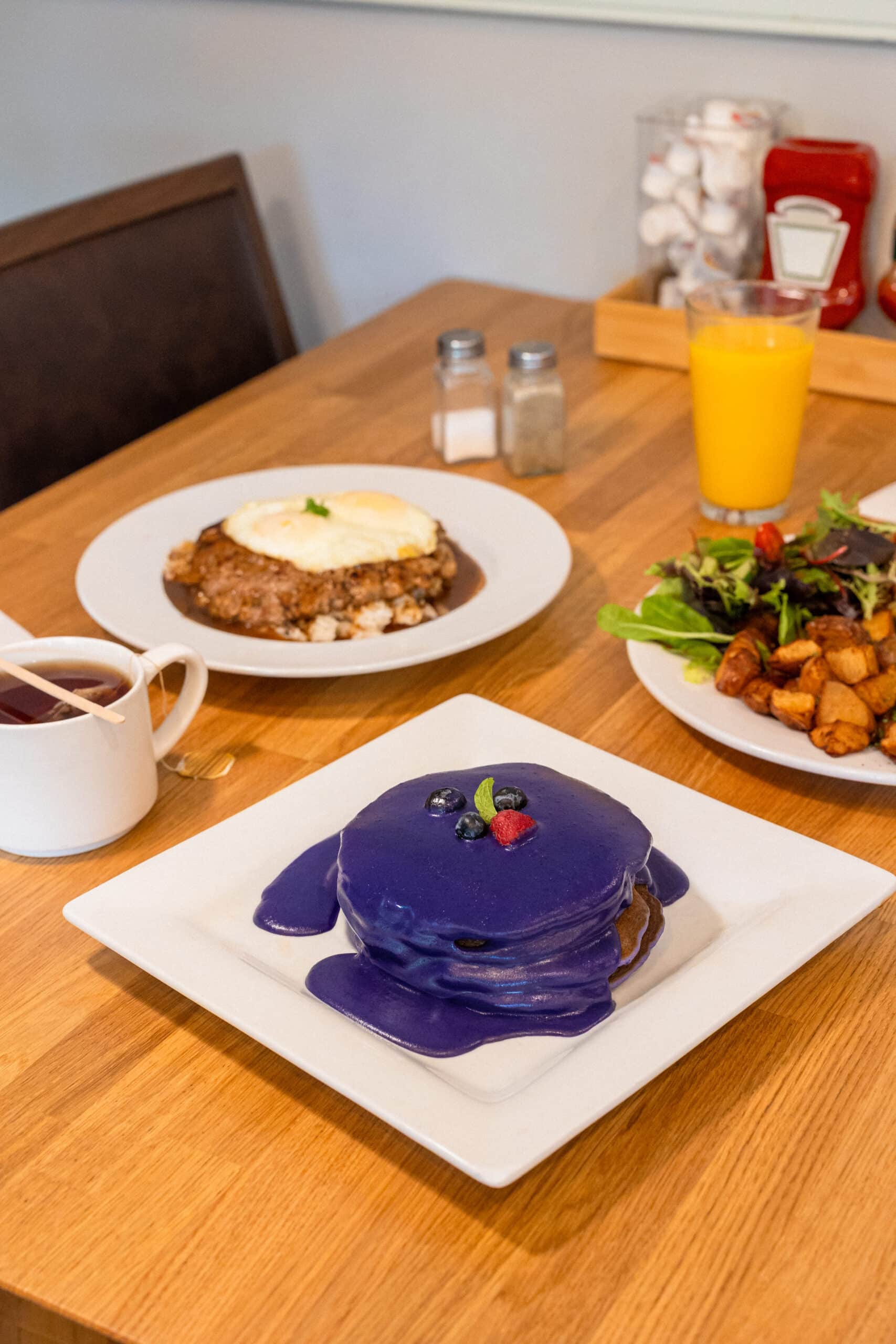Brunch dishes at Yogur Story Honolulu including loco moco, roasted potatoes, salad, and fresh juice