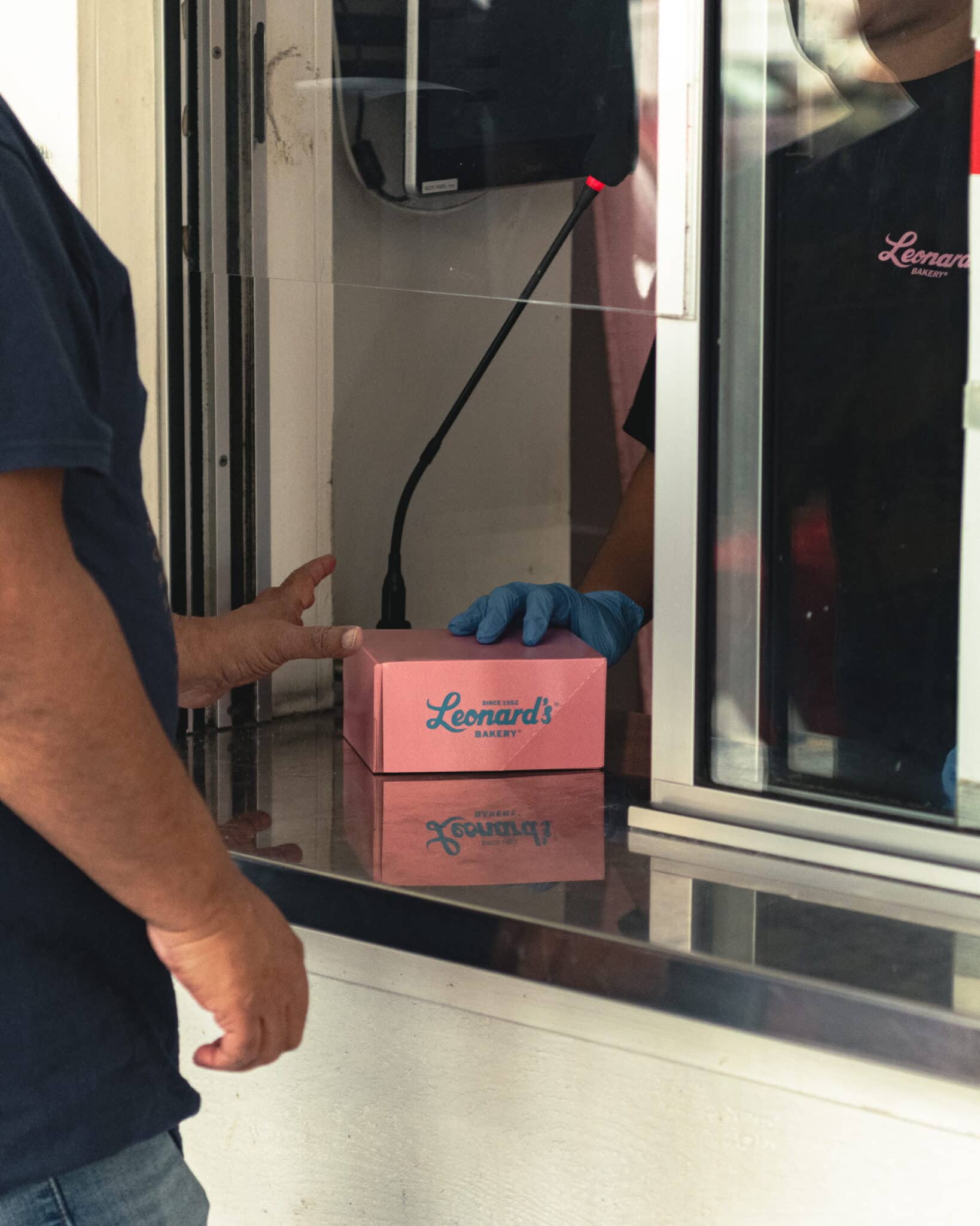 Customer picking up fresh malasadas at Leonard's Bakery